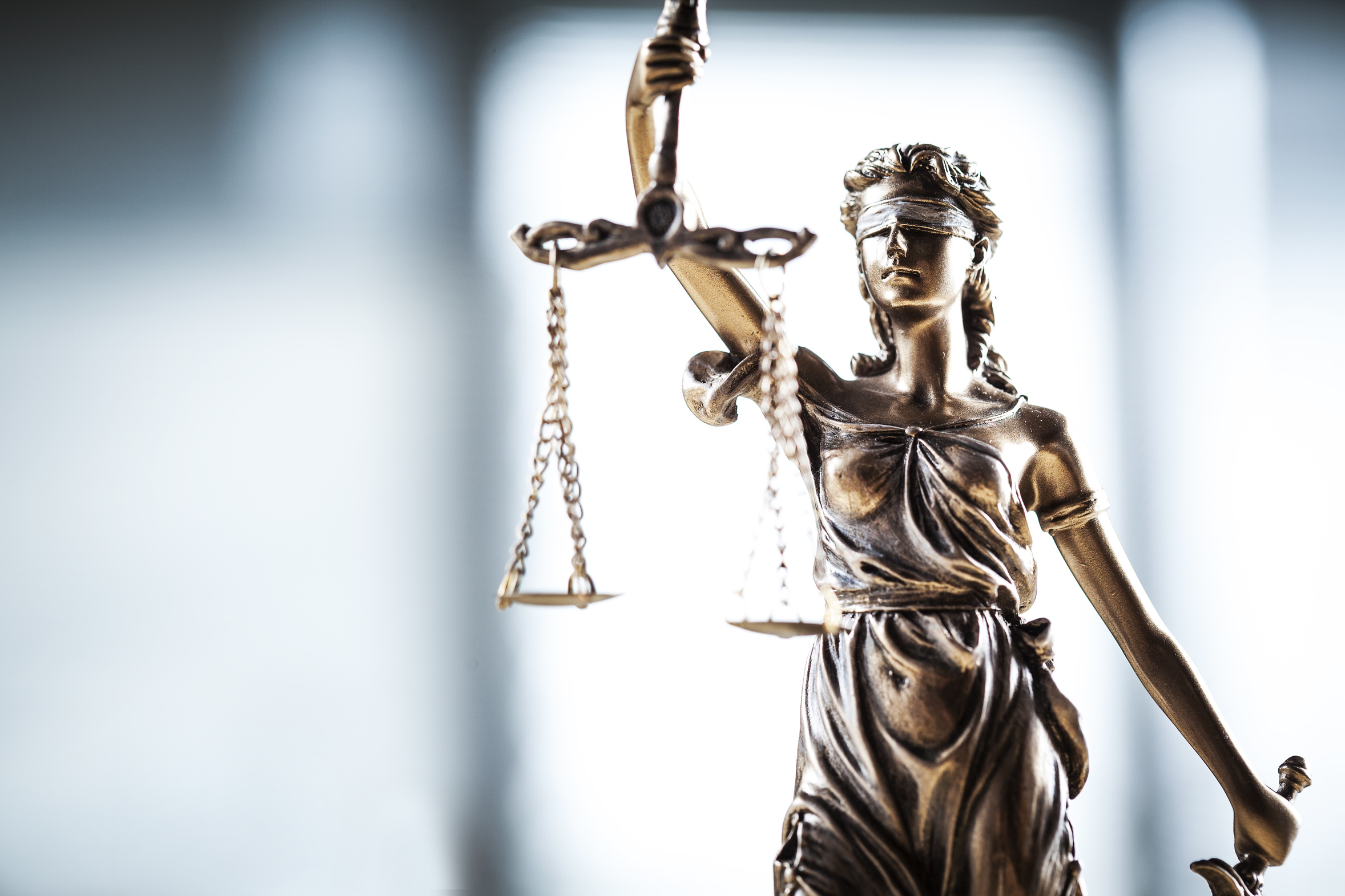 Eine Statue der Justitia, blindfolded, mit einer Waage in der Hand.